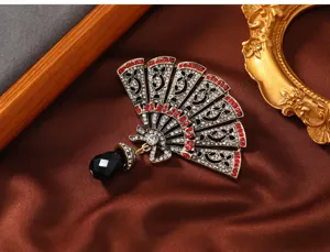 Macro-detail van vintage Chinese waaierbroche met rode strassteentjes en zwart kristal