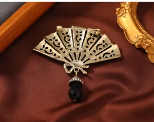 Detailweergave van een vintage Chinese waaierbroche met een zwarte kristallen hanger.