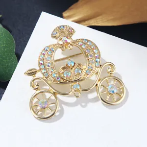 Detailed close-up view of a golden pumpkin carriage brooch with colorful rhinestones