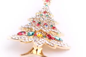 Detailed macro view of colorful rhinestones on a gold-plated Christmas tree brooch.