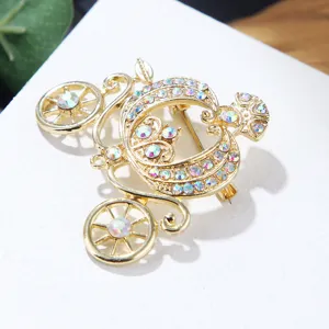 Detailed close-up view of a vintage gold pumpkin carriage brooch with sparkling rhinestones.