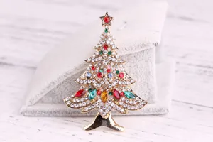 Close-up of a Christmas tree brooch featuring colorful rhinestones on a gold-plated alloy frame