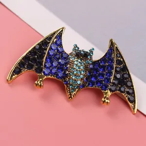 Detailed view of a creative bat-shaped brooch with sparkling blue and black rhinestones