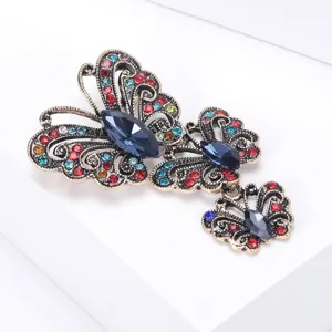 Primer plano detallado de un broche de mariposa vintage con cristales azules y pedrería