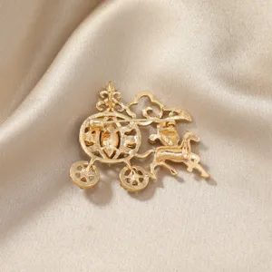 Detailed back view of a golden hollow pumpkin carriage brooch on silk background
