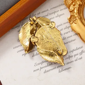 Vista posterior de un broche de hoja de fresa dorado vintage con alfiler de cierre