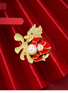 Primo piano di una spilla a forma di drago dorato con una perla e carattere cinese della fortuna.