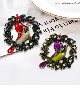 Nahaufnahme von zwei eleganten Vintage-Emaille-Vogelkranz-Broschen mit Strasssteinen