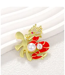 Dettaglio di una spilla a forma di dragone cinese con smalto rosso, perla e oro.