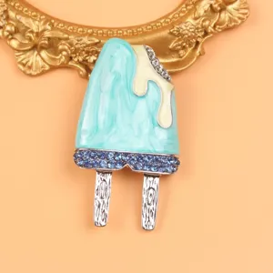 Close-up of a cute blue enamel ice cream popsicle brooch with sparkling blue rhinestones.