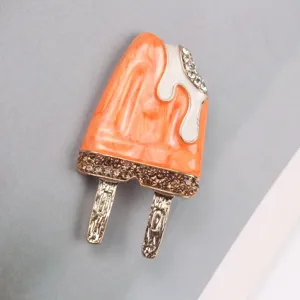 Close-up view of a cute popsicle enamel brooch with sparkling crystals and swirl patterns.
