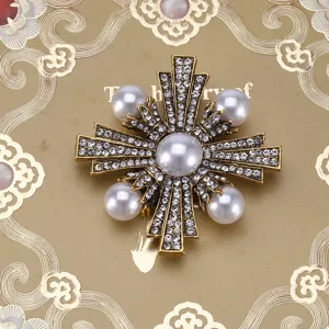 Vintage Baroque gold brooch with white pearls and crystals on a luxury gold background