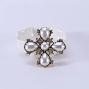 Vintage Baroque style cross brooch featuring white faux pearls and sparkling crystals in gold