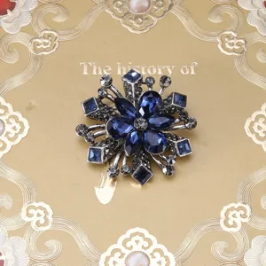 Vintage Baroque flower brooch pin with deep blue crystals and antique silver-toned finish.