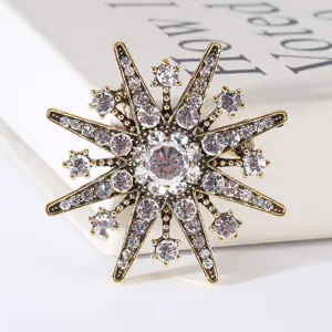 Vintage Baroque star brooch with sparkling clear rhinestones in antique gold finish.