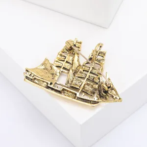 Gedetailleerd achteraanzicht van een gouden zeilschipbroche met veilige speldsluiting