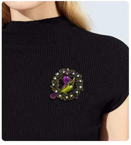 Detailansicht einer eleganten Vogelkranz-Brosche mit buntem Emaille und funkelnden Strasssteinen