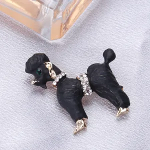 Gros plan d'une broche caniche noire avec collier de cristaux et œil vert détail.