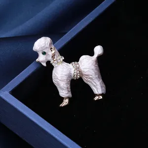 Élégante broche caniche en émail blanc avec strass brillants et détail d'œil vert.