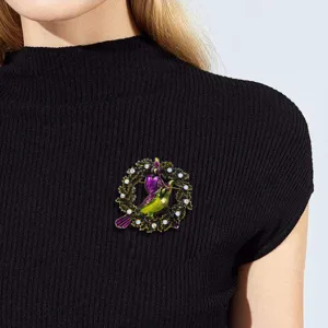 Vintage-Vogelkranz-Brosche mit buntem Emaille- und Strassbesatz auf schwarzem Pullover.
