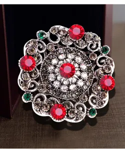 Detailed view of a vintage Baroque brooch with vibrant red and green rhinestones