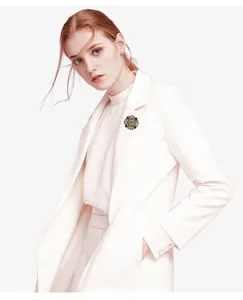 Vintage Baroque palace style brooch shown as a detail on white elegant coat lapel