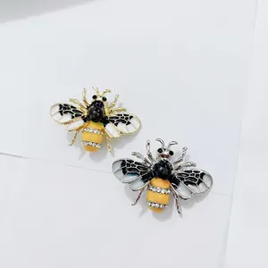 Detailansicht von zwei Emaille-Bienenbroschen mit Strasssteinen in Gold und Silber