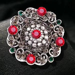 Vintage Baroque circular brooch with red crystals and intricate silver filigree details