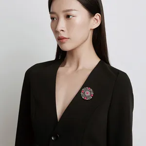 Elegant vintage Baroque palace style brooch with red floral accents on black suit