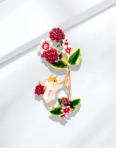 Detalle de un adorable broche de ardilla esmaltada con uvas rojas y hojas verdes.