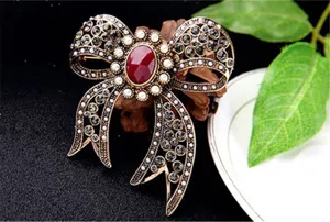 Close-up of a vintage bow brooch with a red gemstone and crystal detailing