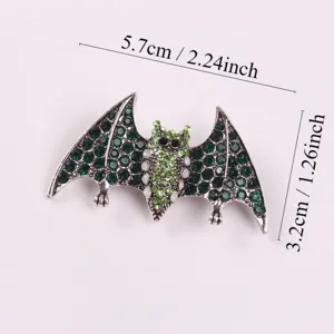 Close-up of a green rhinestone bat brooch with detailed dimensions for size reference.