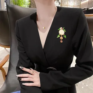 Broche fleur en émail vintage avec visage souriant et pompon sur un blazer noir