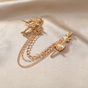 Vintage goudkleurige broche met soldaat en schild bedeltjes verbonden door kwastkettingen