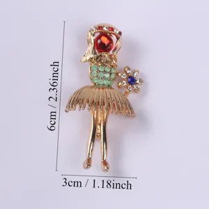 Detailed view of vintage gold-plated girl brooch with green and red rhinestones