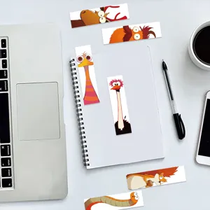 Close-up of funny cartoon animal paper bookmarks with quirky big eyes on a notebook