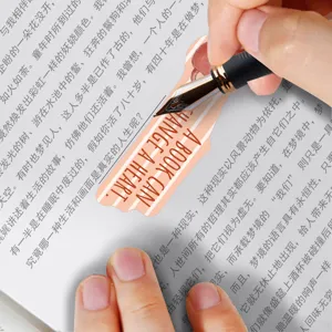 Detailed view of a cute cartoon cat bookmark featuring an inspirational English quote on paper.