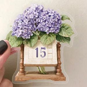 Dettaglio di un adesivo PET vintage con ortensia viola e design a calendario per scrapbooking.