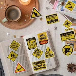 Primer plano de varias pegatinas divertidas de señales de advertencia y peligro en un libro abierto.