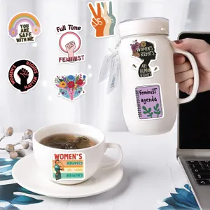 Détail montrant des autocollants féministes appliqués sur une gourde et une tasse
