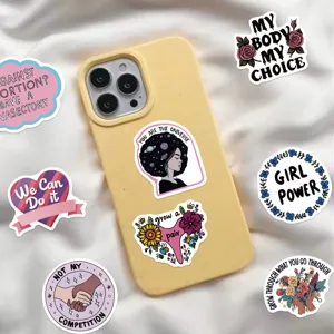 Détail d'autocollants graffiti féministes roses sur une coque de téléphone jaune