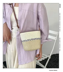 Primer plano de un bolso de paja trenzada con rayas zigzag en un atuendo moderno