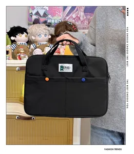Gros plan d'un sac à main noir pour ordinateur avec étiquette et boutons colorés