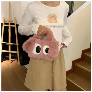 Modelo con un bolso bandolera de peluche rosa con grandes ojos decorativos de dibujos animados.