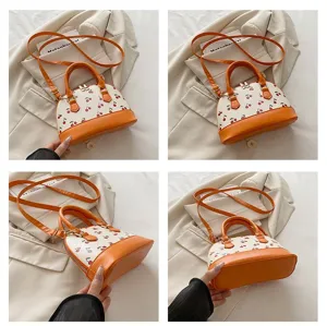 Detaillierte Aufnahmen der stilvollen orangefarbenen Kirsch-Print-Tasche für Damen