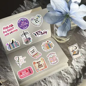 Close-up detail of various bookish stickers with star holographic film on an open notebook