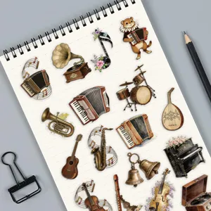 Collection of vintage musical instrument stickers displayed on a notebook page for scrapbooking