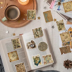 Vintage nautical map stickers featuring compass and antique atlas designs scattered on an open book