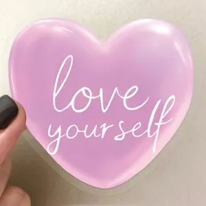 Detailed view of a transparent purple heart sticker with "love yourself" quote for DIY.