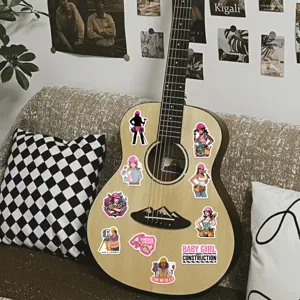 Dettaglio che mostra adesivi di ragazze operaie decorati su una chitarra di legno